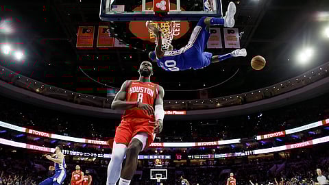 Philadelphia 76ers’ Corey Brewer (00) hangs on the rim above Houston Rockets’ James Ennis III (8) after a dunk during the first half of an NBA basketball game, Monday, Jan. 21, 2019, in Philadelphia. (AP Photo/Matt Slocum)