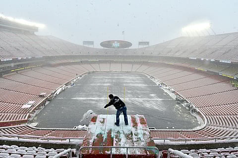 Kyle Haraugh, of NFL Films, clears snow from a camera location at Arrowhead Stadium before an NFL divisional football playoff game between the Kansas City Chiefs and the Indianapolis Colts, in Kansas City, Mo., Saturday, Jan. 12, 2019. (AP Photo/Ed Zurga)