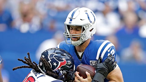 FILE - In this Sept. 30, 2018, file photo, Indianapolis Colts quarterback Andrew Luck (12) is sacked by Houston Texans’ Jadeveon Clowney (90) during the first half of an NFL football game, in Indianapolis. Some juicy rematches highlight wild-card weekend, in which, well, just about any of the eight teams advancing wouldn’t be a surprise. Seattle beat Dallas early this season, and Baltimore handled the Los Angeles Chargers late. The Colts and Texans split two games. Only the Eagles and Bears didn’t face off. (AP Photo/Michael Conroy, File)