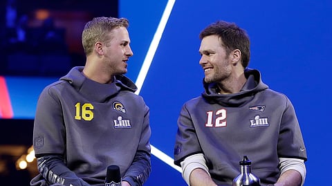 Los Angeles Rams’ Jared Goff talks to New England Patriots’ Tom Brady during Opening Night for the NFL Super Bowl 53 football game Monday, Jan. 28, 2019, in Atlanta. (AP Photo/Matt Rourke)