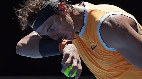Spain’s Rafael Nadal wipes the sweat from his face as he serves to Australia’s James Duckworth against during their first round match at the Australian Open tennis championships in Melbourne, Australia, Monday, Jan. 14, 2019. (AP Photo/Aaron Favila)
