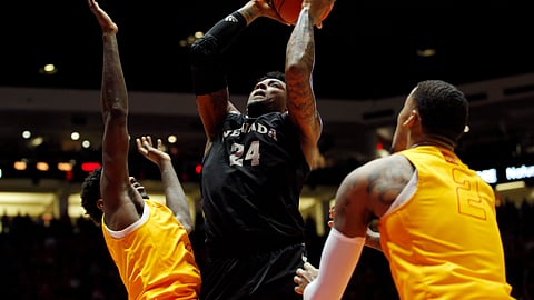Nevada forward Jordan Caroline, center, goes up for a shot as New Mexico’s Corey Manigault, left, and Vance Jackson defend during the first half of an NCAA college basketball game in Albuquerque, N.M., Saturday, Jan. 5, 2019. (AP Photo/Andres Leighton)