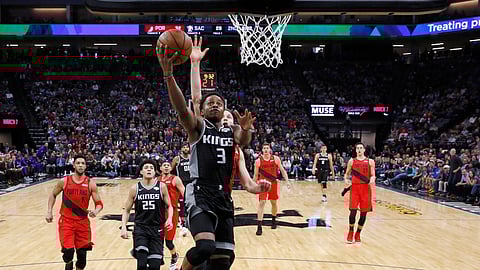 Sacramento Kings guard Yogi Ferrell goes to the basket ahead of Portland Trail Blazers guard Nik Stauskas, behind, during the first half of an NBA basketball game Tuesday, Jan. 1, 2019, in Sacramento, Calif. (AP Photo/Rich Pedroncelli)