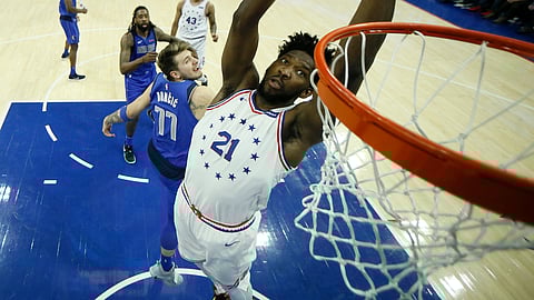 Philadelphia 76ers’ Joel Embiid (21) goes up for a dunk past Dallas Mavericks’ Luka Doncic (77) during the first half of an NBA basketball game, Saturday, Jan. 5, 2019, in Philadelphia. (AP Photo/Matt Slocum)