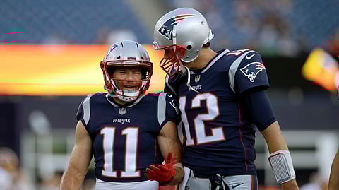 FILE - In this Aug. 9, 2018, file photo, New England Patriots wide receiver Julian Edelman (11) talks with quarterback Tom Brady (12) before a preseason NFL football game against the Washington Redskins in Foxborough, Mass. There’s just two receivers in NFL postseason history with over 100 catches – Jerry Rice with 151 and Edelman with 105. That link has only been strengthened off the field in the past year as Brady and Edelman prepare to play in their fourth Super Bowl together. (AP Photo/Charles Krupa, File)