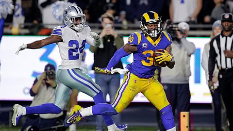 Los Angeles Rams running back Todd Gurley scores past Dallas Cowboys cornerback Chidobe Awuzie during the first half in an NFL divisional football playoff game Saturday, Jan. 12, 2019, in Los Angeles. (AP Photo/Jae C. Hong)