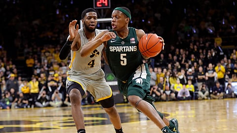 In this January 2019 file photo, Michigan State guard Cassius Winston (5) drives past Iowa guard Isaiah Moss (4) during an NCAA college basketball game in Iowa City, Iowa.
