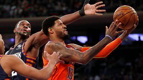 New York Knicks forward Noah Vonleh (32) defends as Oklahoma City Thunder forward Paul George (13) bobbles the ball beneath the Thunder’s basket during the first half of an NBA basketball game, Monday, Jan. 21, 2019, in New York. (AP Photo/Kathy Willens)