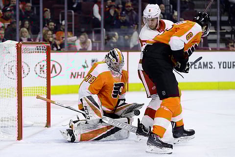 Philadelphia Flyers’ Carter Hart, left, blocks a shot as Detroit Red Wings’ Justin Abdelkader, center, and Travis Sanheim look for the rebound during the first period of an NHL hockey game, Tuesday, Dec. 18, 2018, in Philadelphia. (AP Photo/Matt Slocum)