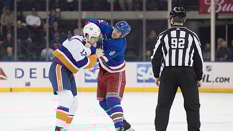 Linesman Mark Shewchyk (92) watches New York Islanders left wing Matt Martin (17) fight New York Rangers left wing Cody McLeod (8) during the first period of an NHL hockey game, Thursday, Jan. 10, 2019, at Madison Square Garden in New York. (AP Photo/Mary Altaffer)