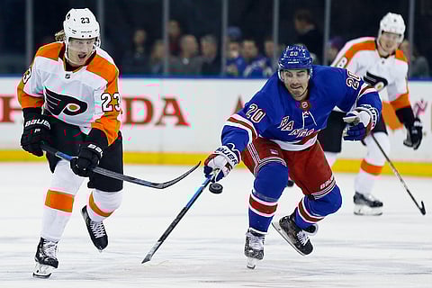 Philadelphia Flyers left wing Oskar Lindblom (23) passes the puck past New York Rangers left wing Chris Kreider (20) in the first period of an NHL hockey game Tuesday, Jan. 29, 2019, in New York. (AP Photo/Adam Hunger)