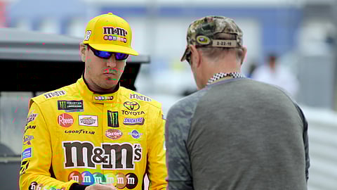 Kyle Busch, left, gives an autograph before qualifying for the NASCAR Daytona 500, Sunday, Feb. 10, 2019, in Daytona Beach, Fla. (AP Photo/Terry Renna)