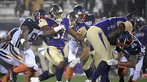 Atlanta Legends running back Lawrence Pittman rushes in front of Orlando Apollos defensive end Anthony Moten Jr. during an Alliance of American Football game (AP Photo/Phelan M. Ebenhack)