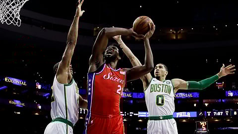 Philadelphia 76ers’ Joel Embiid goes up for a shot between Boston Celtics’ Al Horford, left, and Jayson Tatum. (AP Photo/Matt Slocum)