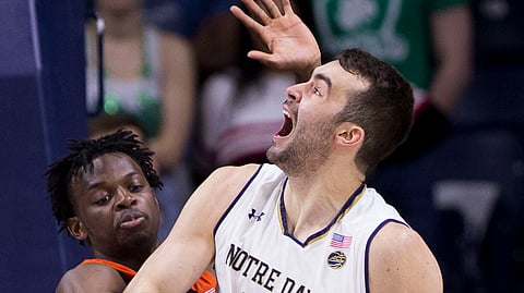 Virginia Tech’s Jonathan Kabongo, left, grabs the ball as Notre Dame’s John Mooney, right, attempts a shot. (Robert Franklin)
