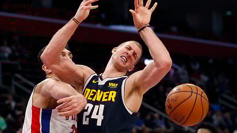 Detroit Pistons center Zaza Pachulia knocks the ball away from Denver Nuggets forward Mason Plumlee (24), Monday, Feb. 4, 2019, in Detroit. (AP Photo/Carlos Osorio)