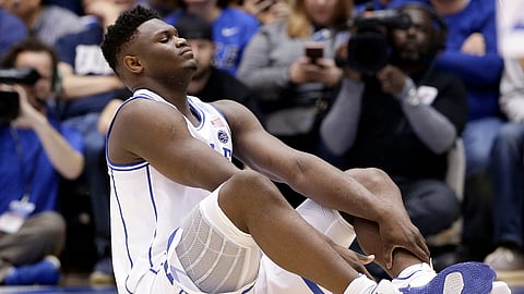 Duke’s Zion Williamson sits on the floor following an injury against North Carolina in Durham, N.C., Wednesday, Feb. 20, 2019. (AP Photo/Gerry Broome)