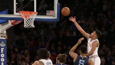 New York Knicks’ Dennis Smith Jr., right, sinks a basket over Memphis Grizzlies defenders during the first half of an NBA basketball game, Sunday, Feb. 3, 2019, in New York. (AP Photo/Seth Wenig)