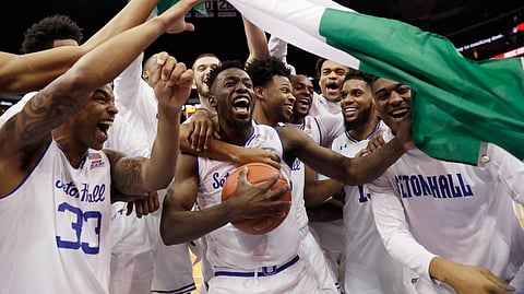 Seton Hall forward Michael Nzei, center, celebrates with teammates and a Nigerian flag after Seton Hall Seton Hall defeated Villanova 79-75 March 9, 2019, in Newark, N.J. (AP Photo/Kathy Willens)