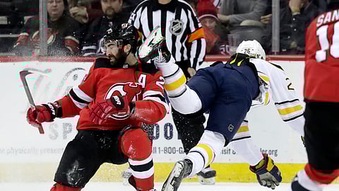 Buffalo Sabres defenseman Rasmus Dahlintrips over New Jersey Devils right wing Kyle Palmieri and ain’t that a kick in the head. (AP Photo/Julio Cortez)
