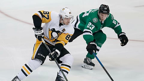Pittsburgh Penguins center Sidney Crosby and Dallas Stars defenseman Esa Lindell skate for the puck during the game on March 23, 2019. 