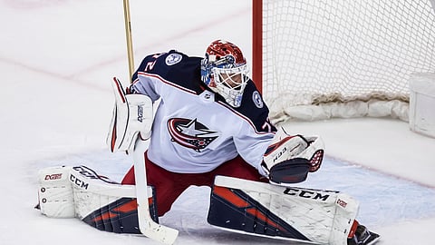 Columbus goalie Sergei Bobrovsky reaches for a puck against the Canucks Sunday (Darryl Dyck/The Canadian Press)