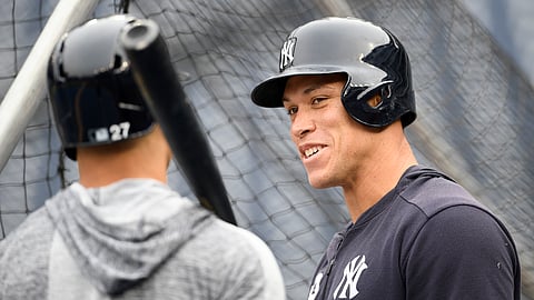 New York Yankees right fielder Aaron Judge, right, talks with left fielder Giancarlo Stanton, left, during batting practice before an exhibition baseball game against the Washington Nationals, on March 25, 2019. 