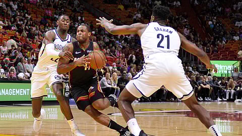 Brooklyn’s Caris LaVert and Treveon Graham defend against a driving Dion Waiters of the Heat Saturday (Gaston De Cardenas)