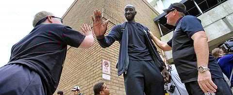 Colt Kohler (age 11) gets a high-five from Central Florida center Tacko Fall and dad Erik Kohler looks on as UCF departs for the NCAA Tournament (Joe Burbank/Orlando Sentinel)
