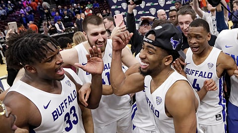 Buffalo’s CJ Massinburg and Nick Perkins (left) and teammates celebrate NCAA bird Saturday (Tony Dejak)