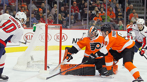 Washington Capitals’ Brett Connolly, left, scores past Philadelphia Flyers goalie Carter Hart, and Ivan Provorov, on March 14, 2019. (Tom Mihalek)