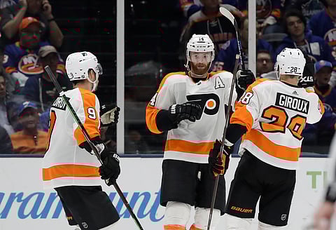 Sean Couturier (center) is congratulated by Flyers teammates Ivan Provorov (left) and Robert Hagg after scoring a goal Sunday against the Islanders (Kathy Willens)