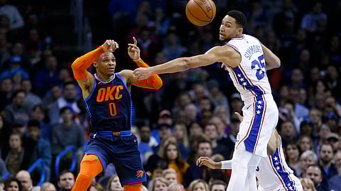 Oklahoma City’s Russell Westbrook passes around Sixer Ben Simmons Thursday (Sue Ogrocki)