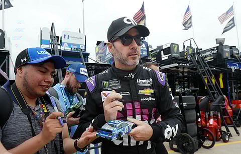 Jimmie Johnson looks up while signing autographs before practice at Texas Motor Speedway in Fort Worth, Texas, Friday, March 29, 2019. (AP Photo/LM Otero)
