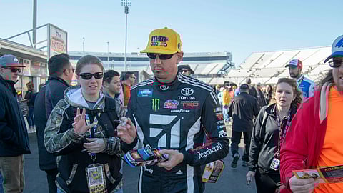 Kyle Bush signs autographs after qualifying second for the NASCAR Gander Outdoors Truck Series race at Martinsville Speedway on March 23