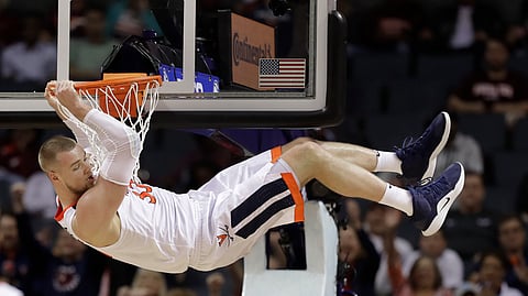 Virginia’s Jack Salt (33) hangs from the rim after a dunk against North Carolina St. in the ACC tournament, Thursday, March 14, 2019.  (AP Photo/Chuck Burton)