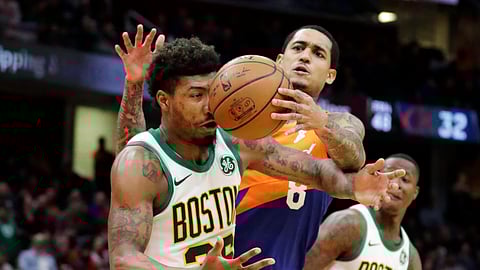 Boston Celtics’ Marcus Smart, left, and Cleveland Cavaliers’ Jordan Clarkson battle for a loose ball in the second half of an NBA basketball game on March 26, 2019.