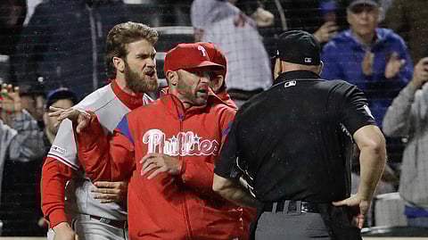 Philadelphia Phillies manager Gabe Kapler, center, restrains Bryce Harper, left, while arguing a call with umpire Mark Carlson during the fourth inning of a baseball game on April 22, 2019.