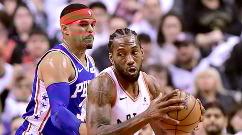 Philadelphia 76ers forward Tobias Harris, left, watches as Toronto Raptors forward Kawhi Leonard moves the ball during the first half of Game 1 of a second-round NBA basketball playoff series on April 27, 2019.