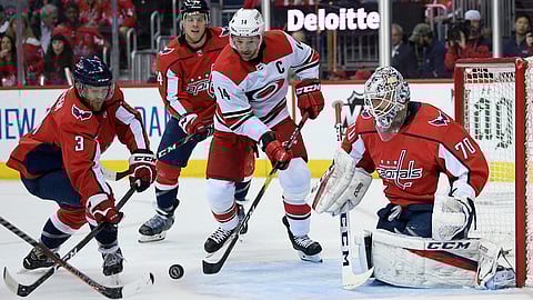 Washington Capitals defenseman Nick Jensen (3) and goaltender Braden Holtby (70) battle for the puck against Carolina Hurricanes right wing Justin Williams (14) during the first period of Game 2 of the NHL hockey first-round playoff serieson April 13, 2019.