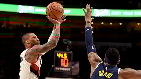Portland guard Damian Lillard shoots over Denver’s Torrey Craig on April 7 (Steve Dykes)
