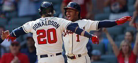 Braves third baseman Josh Donaldson (20) celebrates with Ozzie Albies after hitting a three-run home run in the eighth inning April 28 (John Bazemore)