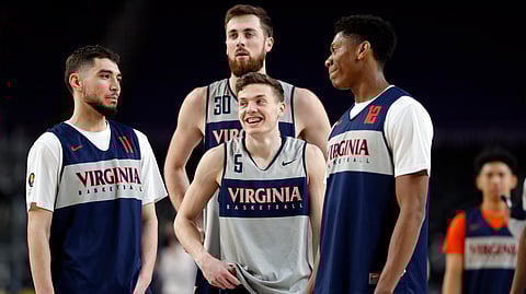 Virginia’s Kyle Guy (5) laughs as he gather with Ty Jerome (11), Jay Huff (30) and De’Andre Hunter (12) during a practice session at the Final Four, Friday, April 5, 2019, in Minneapolis. (AP Photo/Charlie Neibergall)