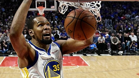 Golden State Warriors forward Kevin Durant, top, dunks as Los Angeles Clippers guard Landry Shamet defends during the second half in Game 4 of a first-round NBA basketball playoff series on April 21, 2019.