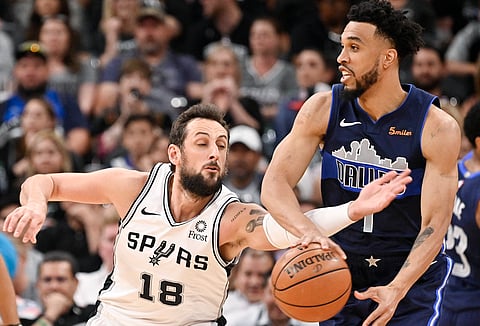 San Antonio’s Marco Belinelli goes for the ball as he defends Mavericks’ Courtney Lee Wednesday (Darren Abate)