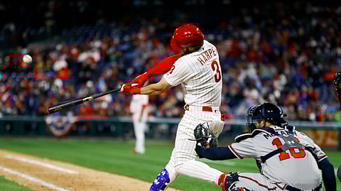 Philadelphia Phillies’ Bryce Harper, left, hits a homerun off Atlanta Braves relief pitcher Shane Carle during the seventh inning on March 31, 2019.