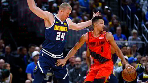 Portland Trail Blazers guard CJ McCollum, right, drives past Denver Nuggets forward Mason Plumlee in the first half of Game 7 of an NBA basketball second-round playoff series Sunday, May 12, 2019, in Denver. (AP Photo/John Leyba)