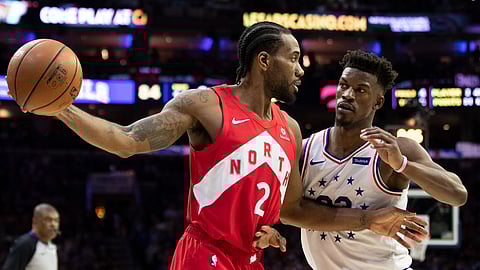 Toronto Raptors’ Kawhi Leonard, left, holds the ball away from Philadelphia 76ers’ Jimmy Butler, right, during the second half of Game 4 of a second-round NBA basketball playoff series on May 5, 2019. 