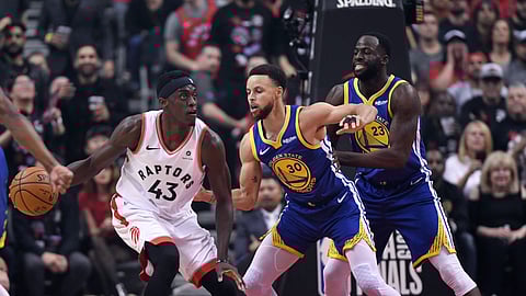 Toronto Raptors forward Pascal Siakam drives on Stephen Curry and Draymond Green back when games had fans.