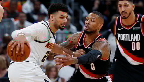 Portland’s Damian Lillard (center) and Enes Kanter look to defend Denver’s Jamal Murray in Game 1 on April 29 (David Zalubowski)